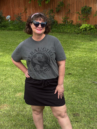 Woman wearing Feral Girl Summer graphic tee and black mini skirt outdoors